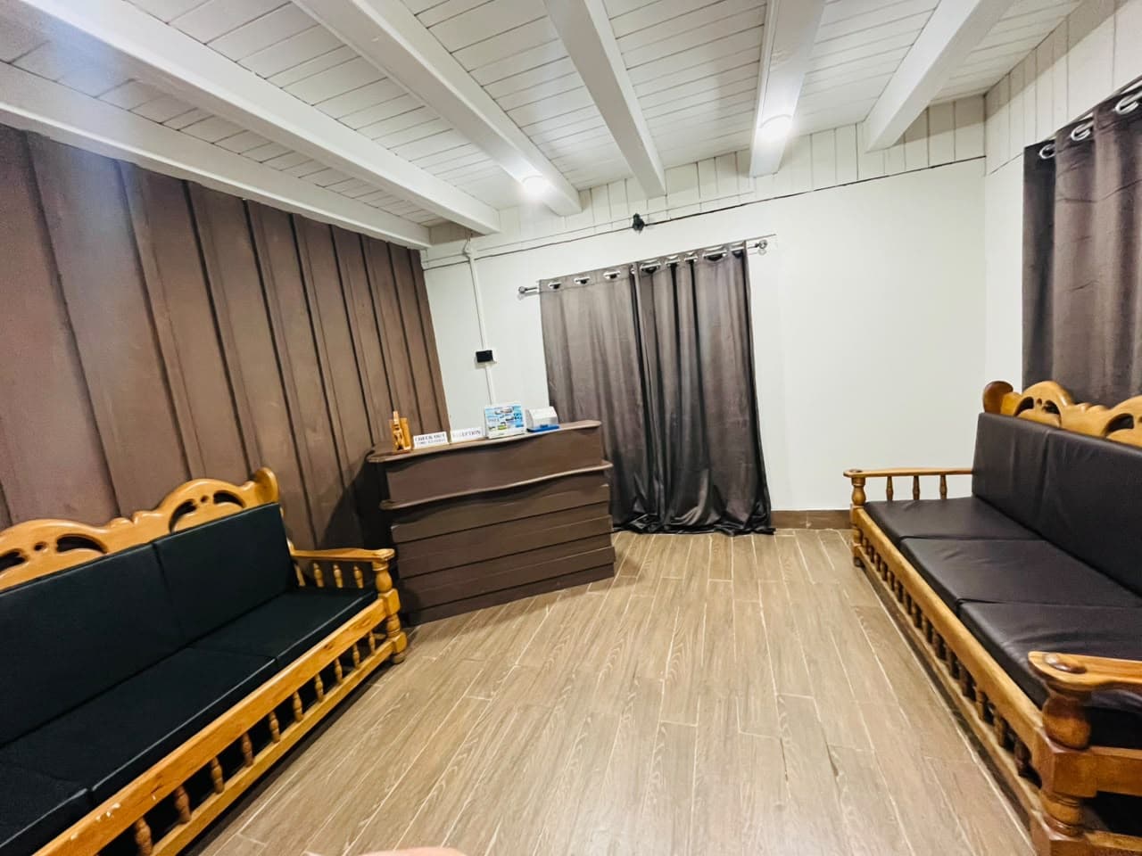 Apex Inn reception desk with wooden sofas in the guest lounge