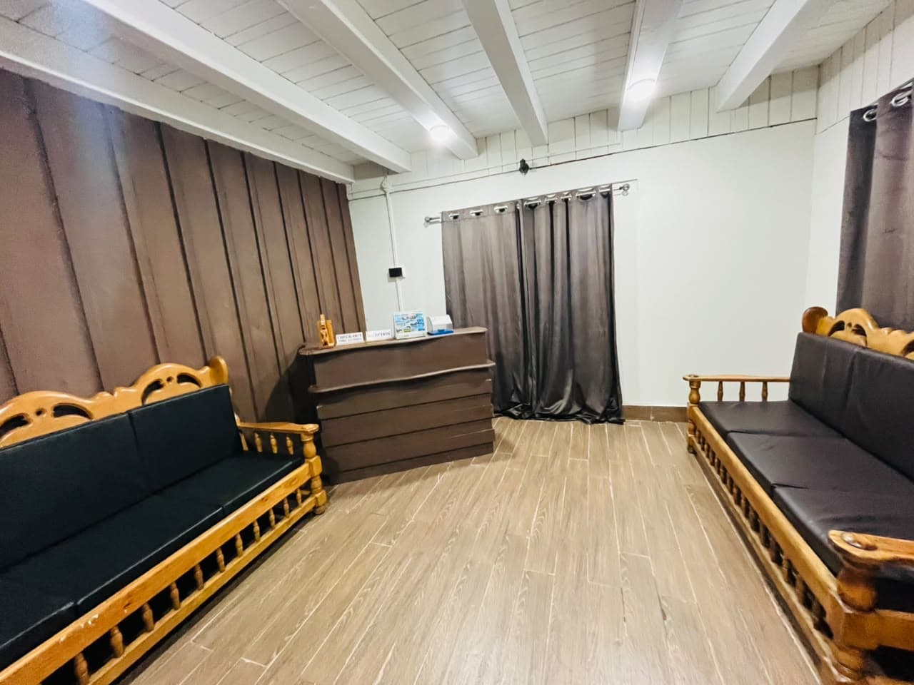 Guest lounge with wooden sofas and a reception desk
