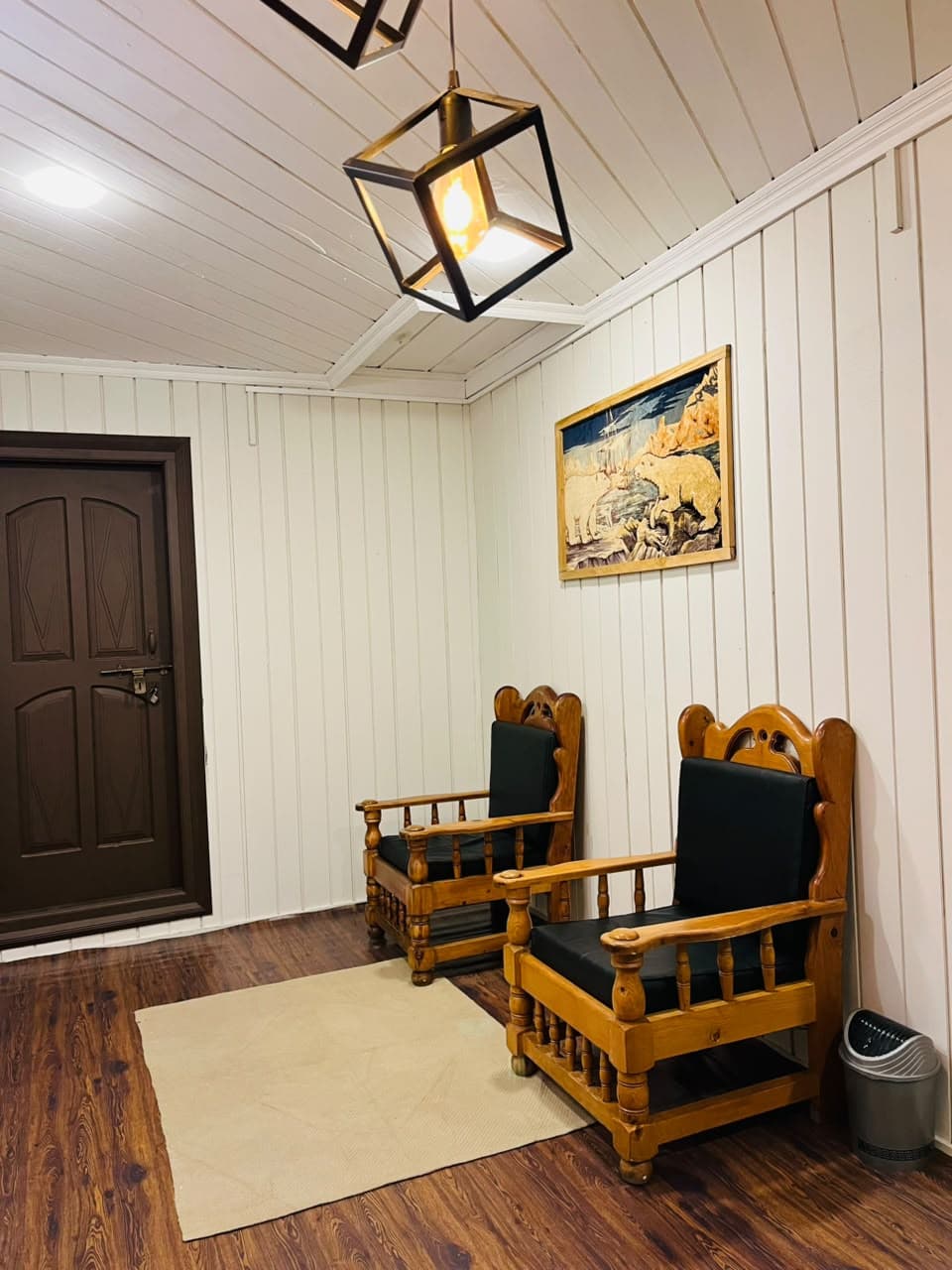 Wooden armchairs beside a door under pendant lights