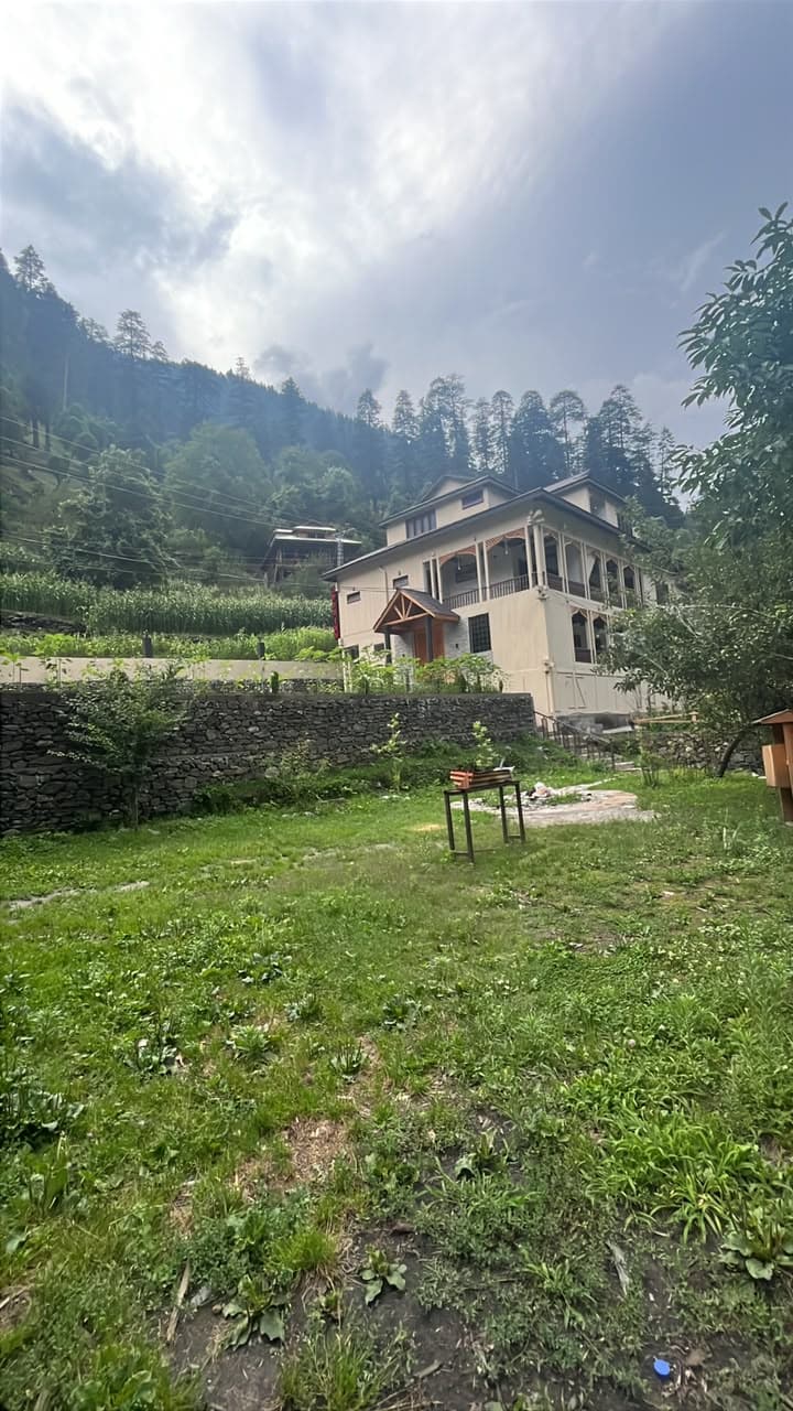 Apex Inn seen across its lawn with pine-covered hills behind