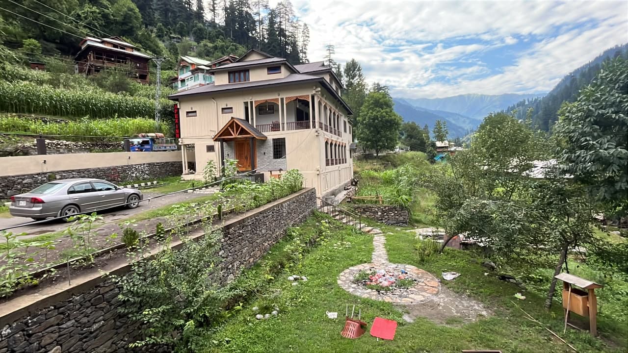 Apex Inn and its gardens with the forested mountains of Neelum Valley behind