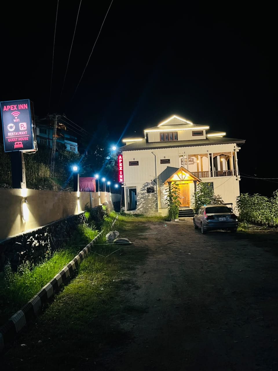 Apex Inn sign and driveway leading to the guest house at night
