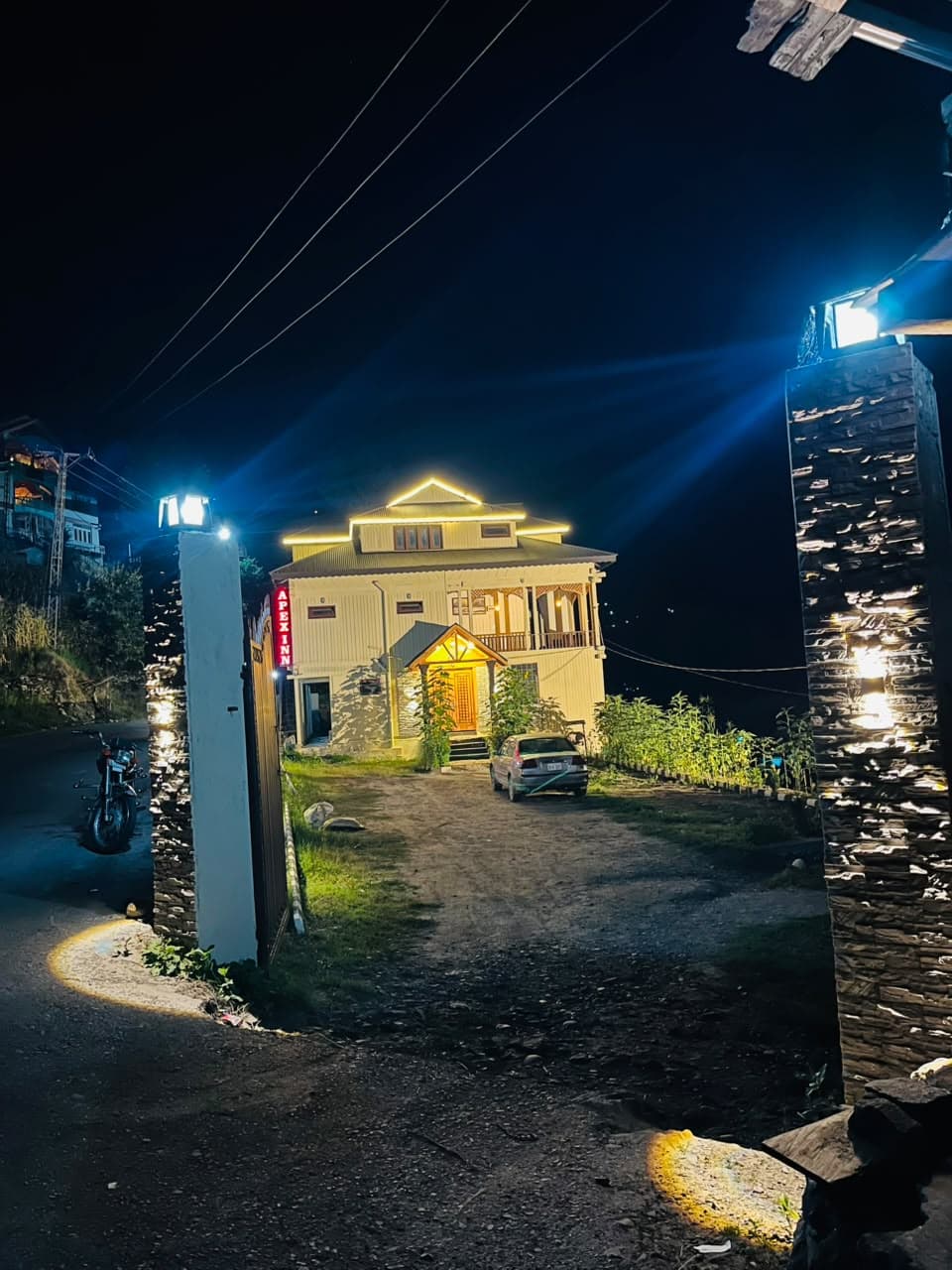 Apex Inn gateway lit at night with the guest house beyond