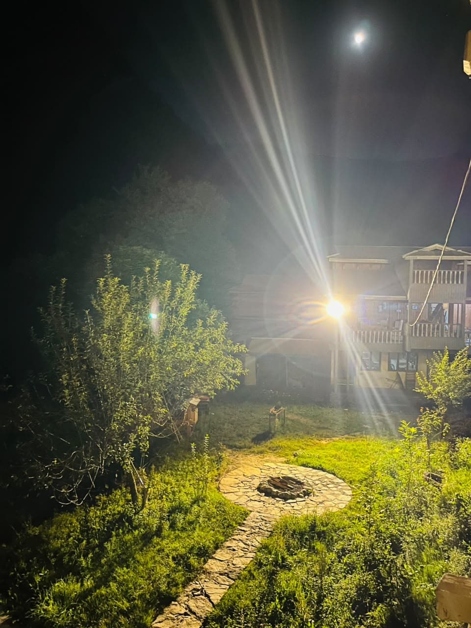 Moonlit garden path leading to the stone fire pit