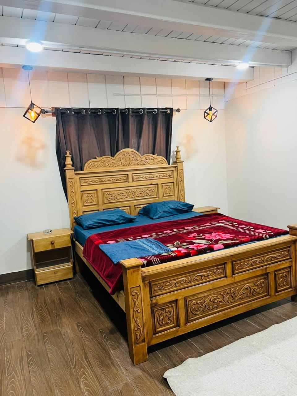 Deluxe Room with a hand-carved wooden king bed and pendant lanterns