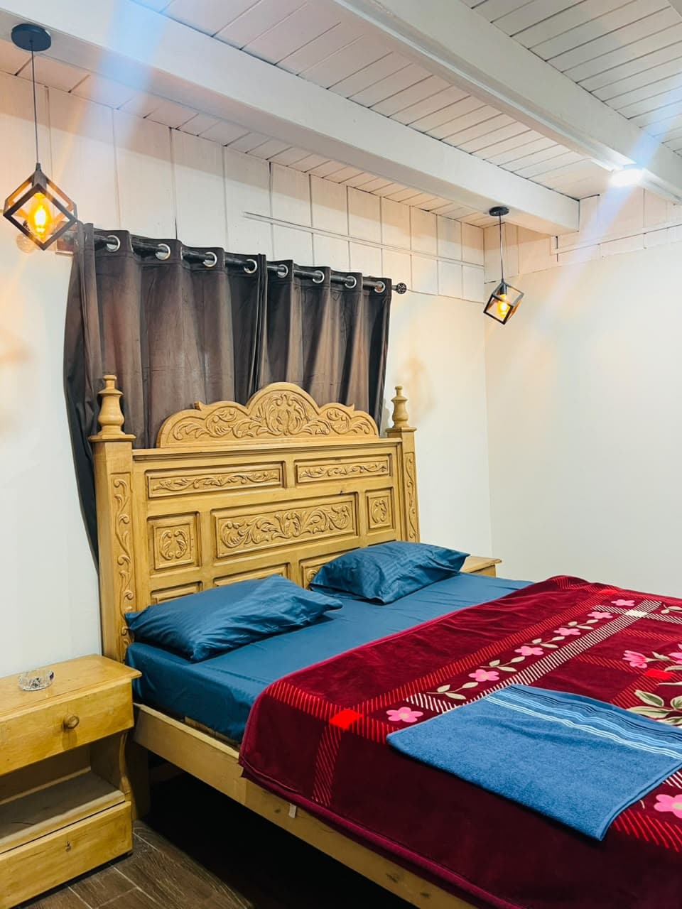 Carved bed beside a wooden bedside table