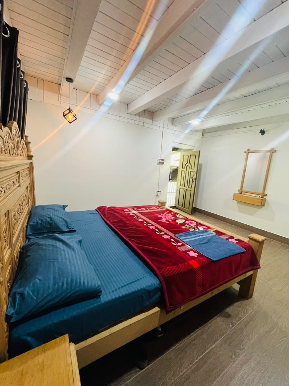 Side view of a carved king bed with blue linen