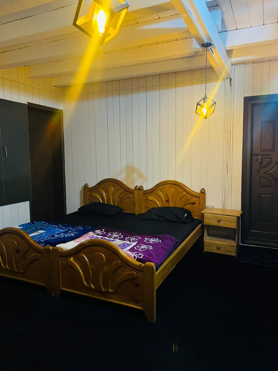 Wooden beds under warm pendant lights