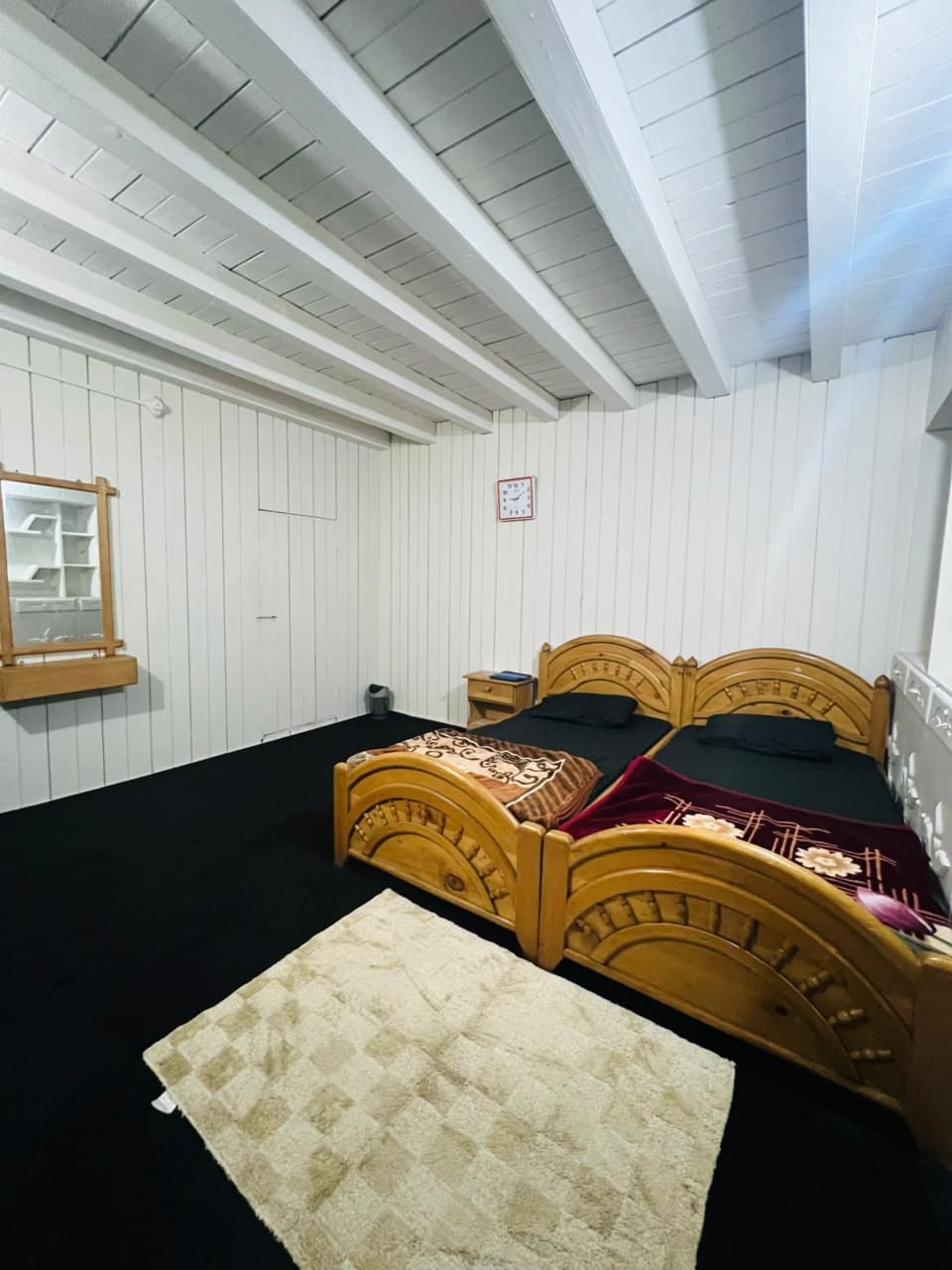 Wooden beds with a rug in a timber-panelled room