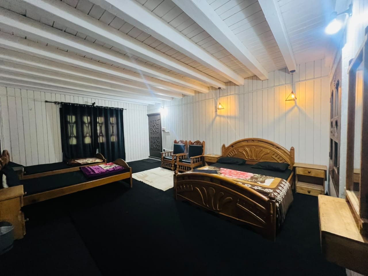 Family room with a double bed, extra bed and wooden armchairs