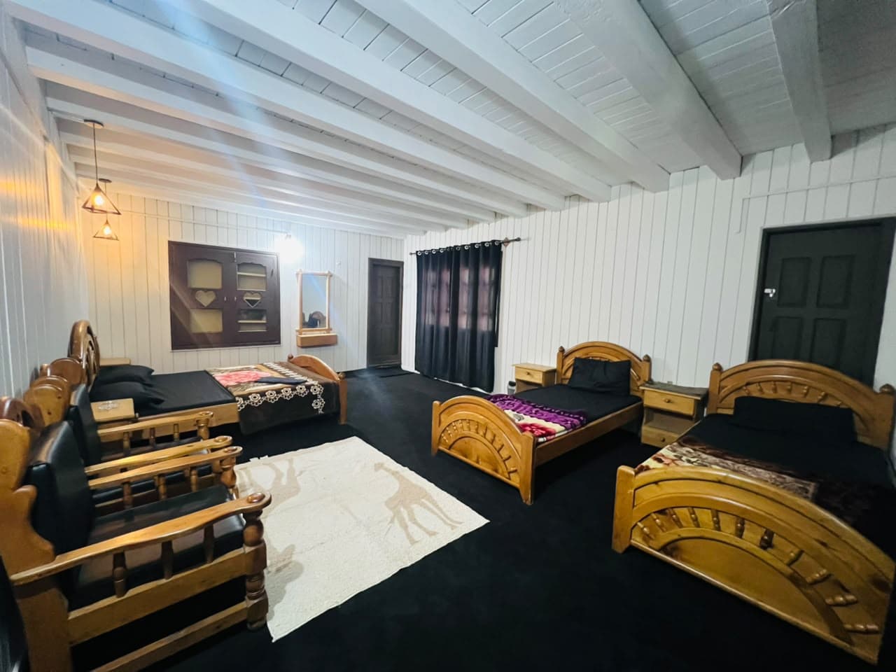 Family Room with a wooden sofa set, rug and three beds