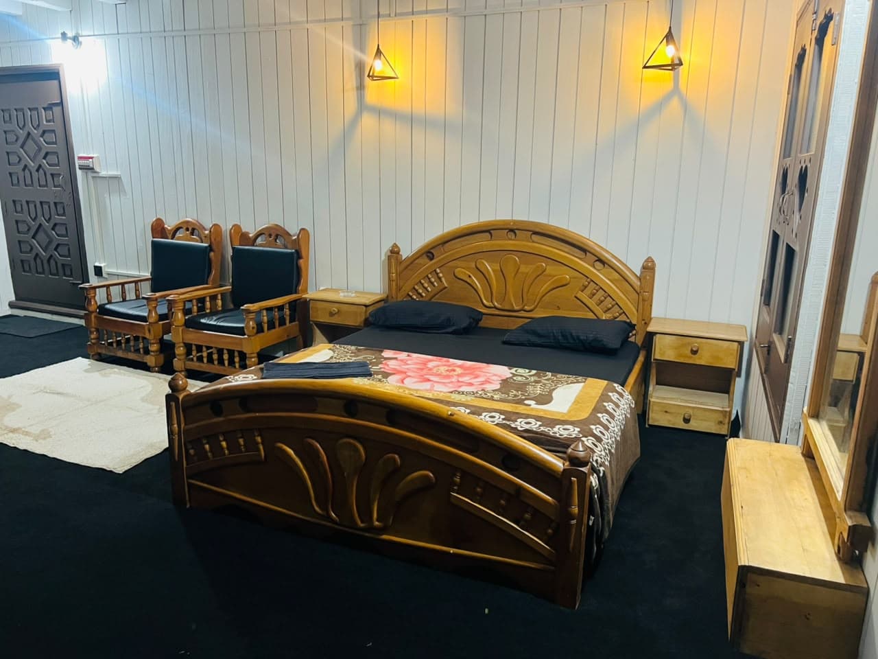 Carved double bed with wooden armchairs