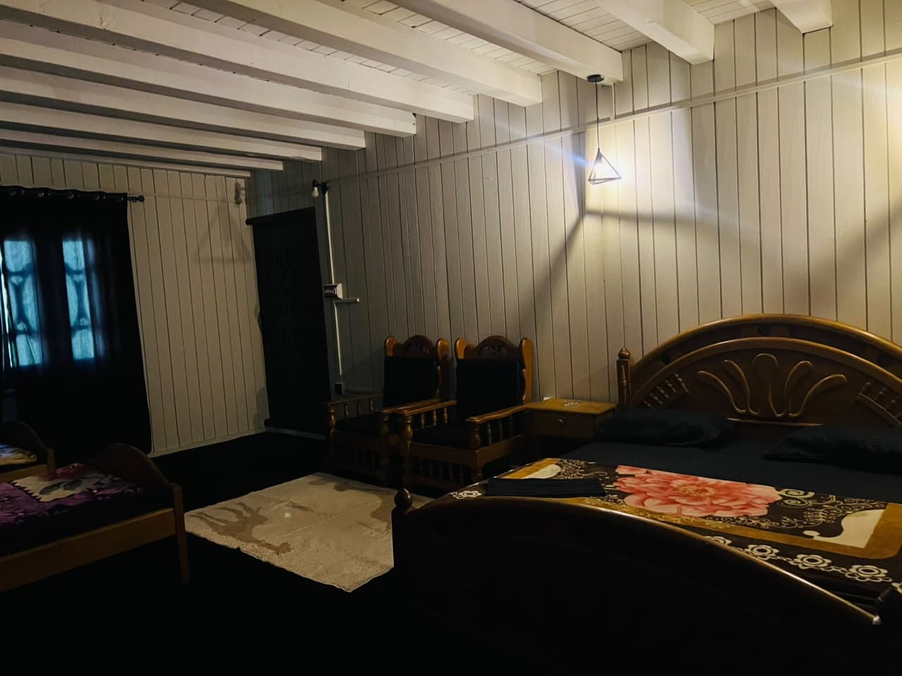Family room bed with armchairs beneath wall lights