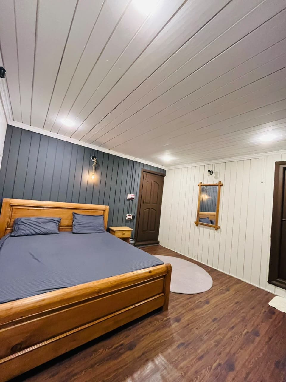 Guest room with a wall mirror and warm wall light