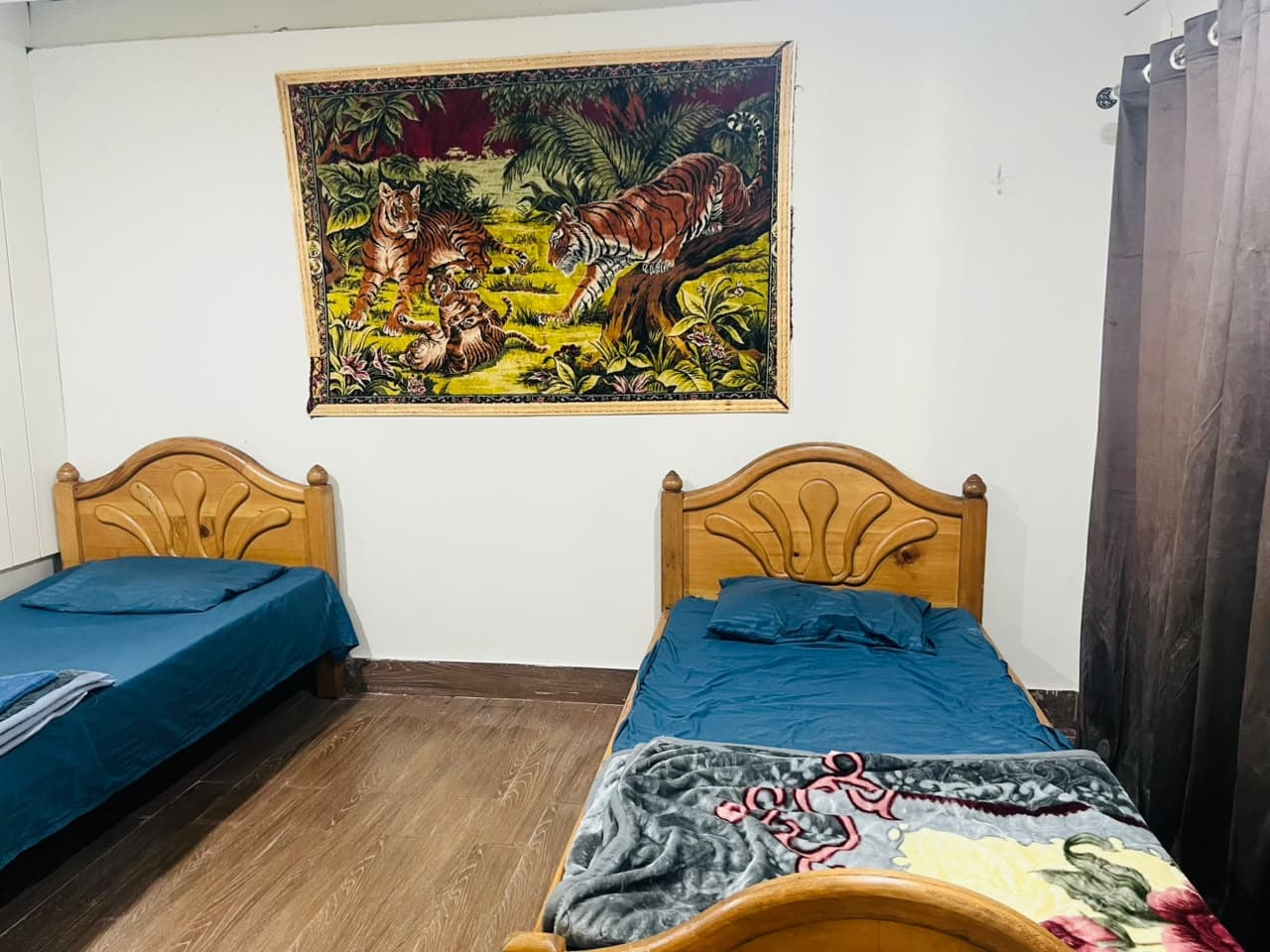 Twin room with two single beds and a tiger tapestry