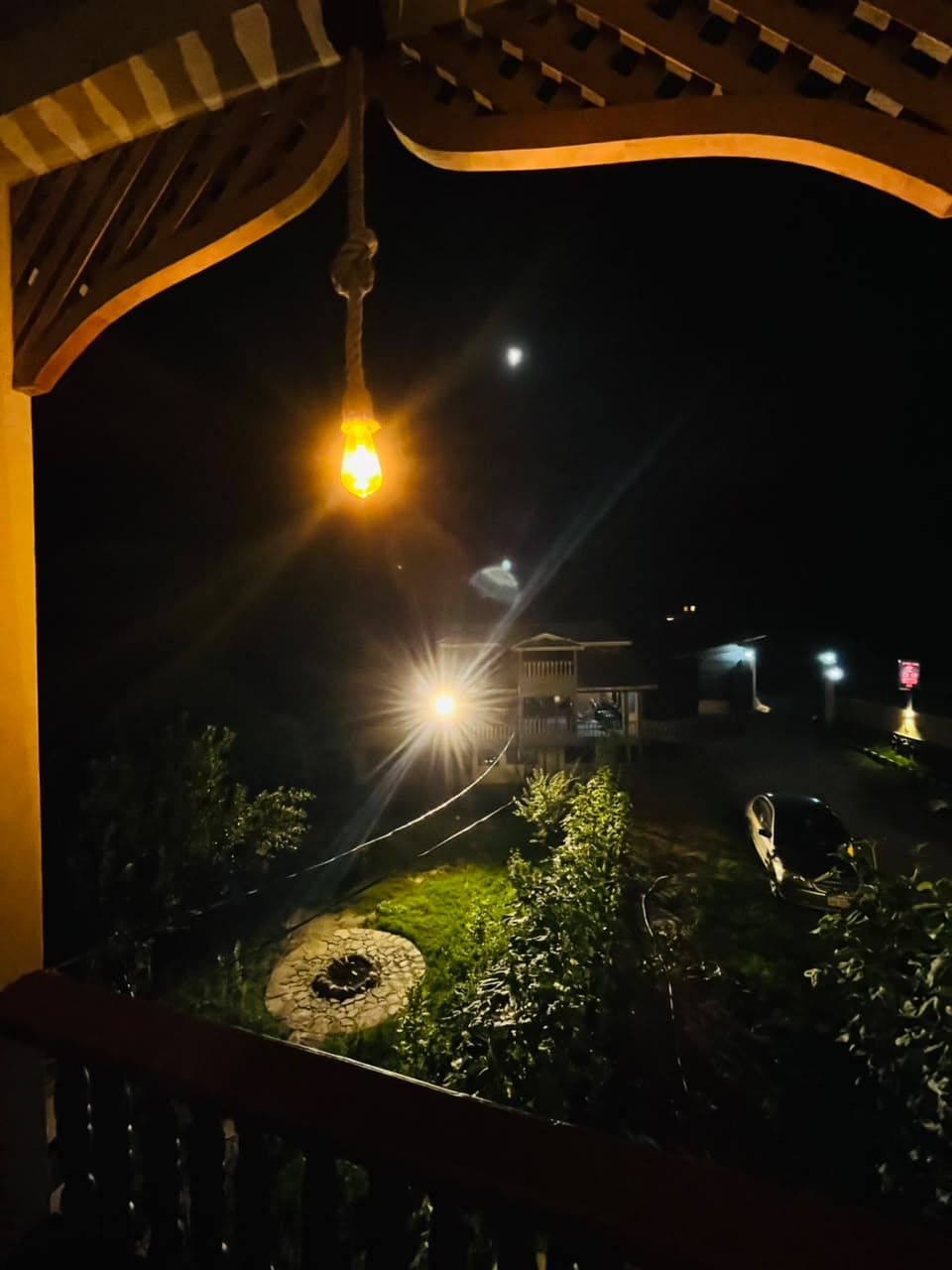 Balcony view of the moonlit garden and fire pit