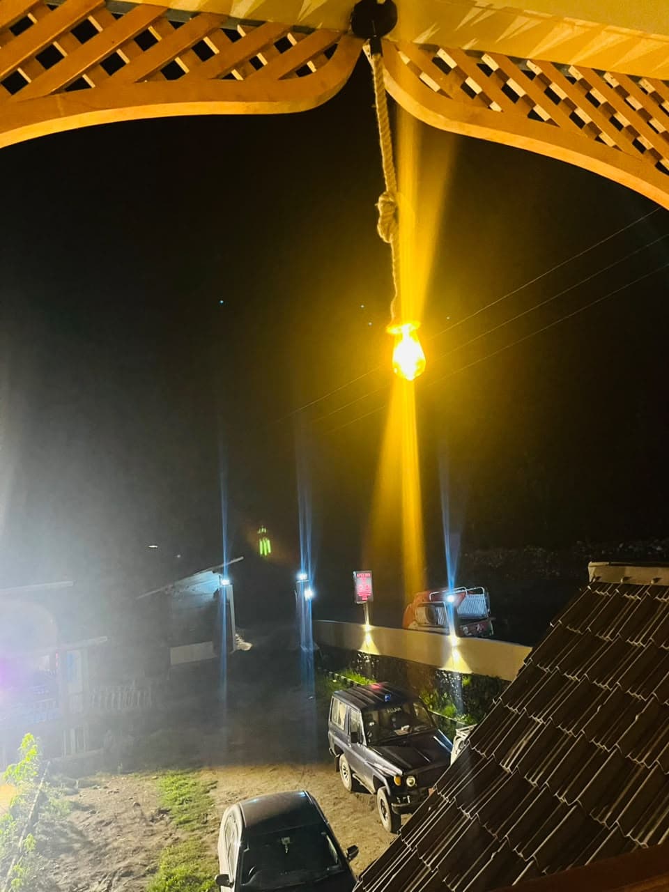 Hanging balcony light glowing over the driveway at night